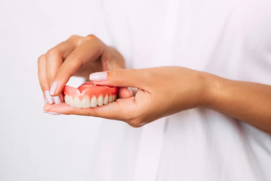 dentures charlotte hands holding upper denture plate