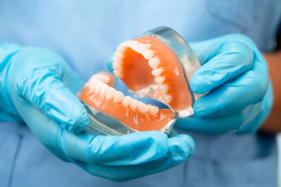 dentures charlotte technician holding full set of dentures